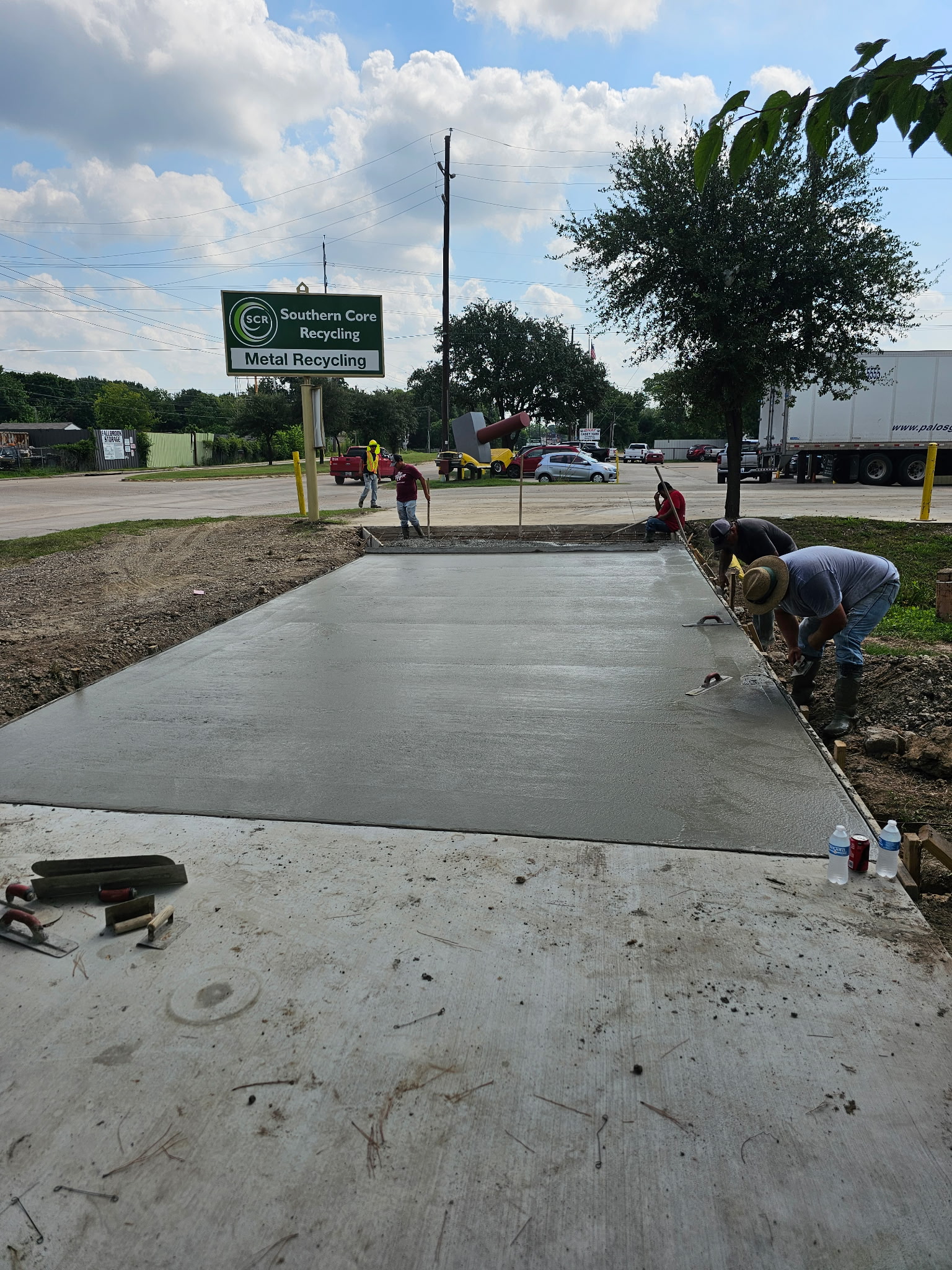 Crew finishing concrete at an industrial property entrance