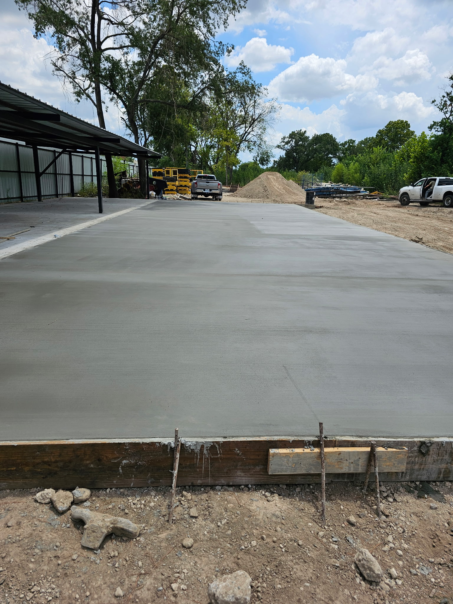 Large concrete slab at a C&M jobsite with trees and open sky behind it